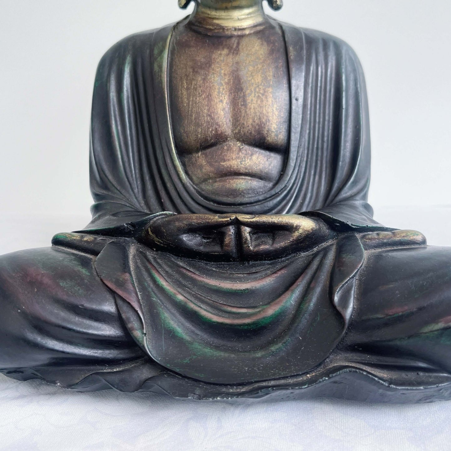 Detail view of buddha sitting in the lotus position.