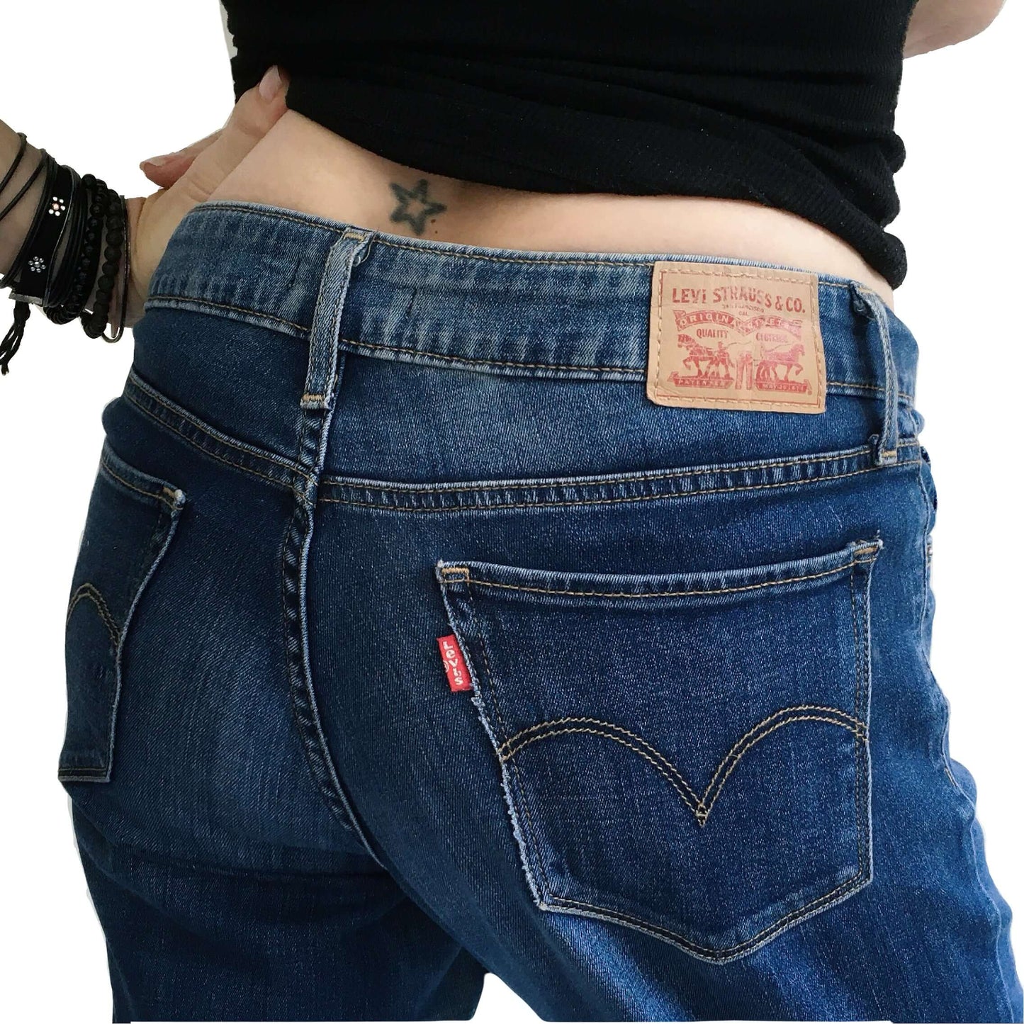 Back detail view of blue jeans, uniform coloration, showing levis label.