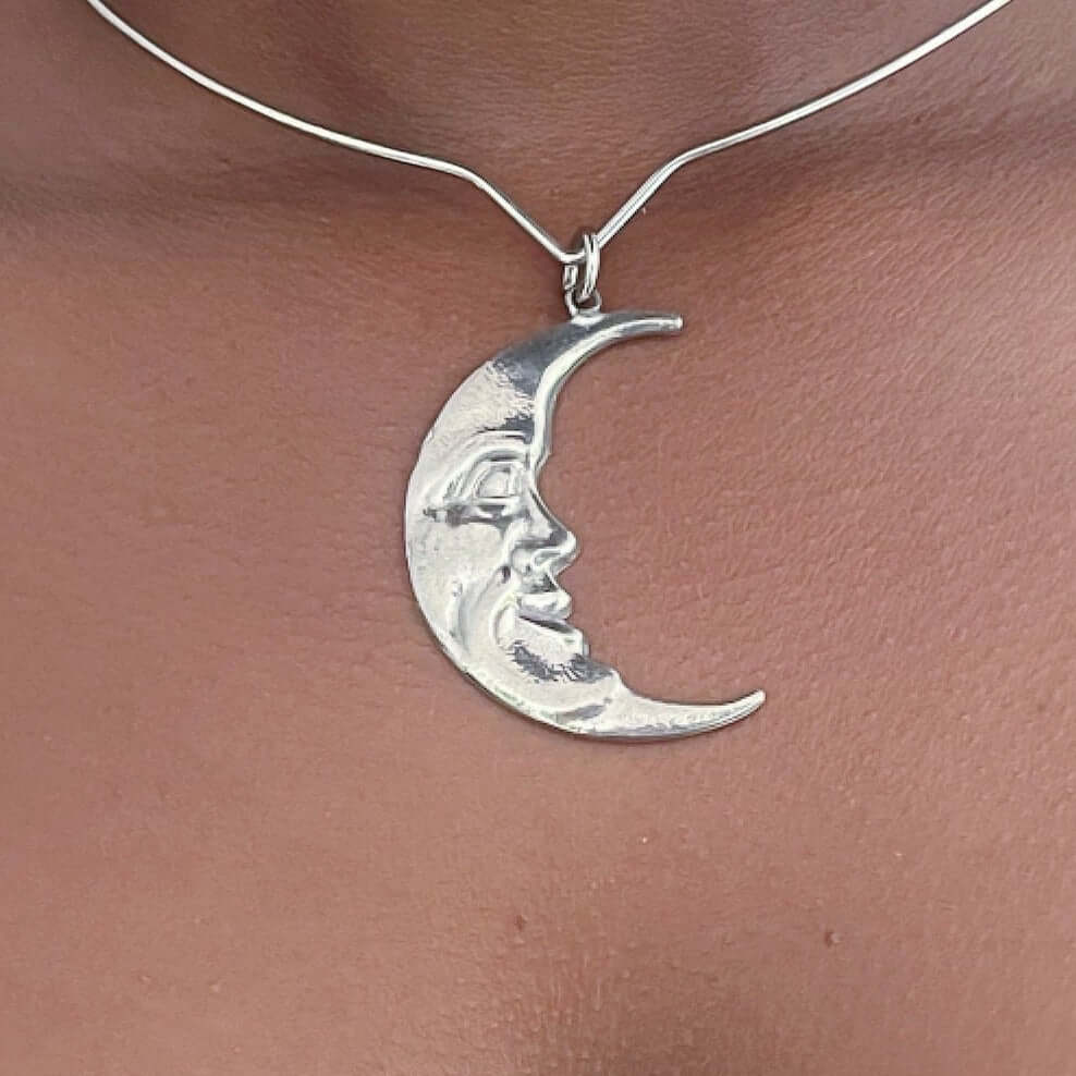 Detail view of pewter art nouveau moon, on steel choker.