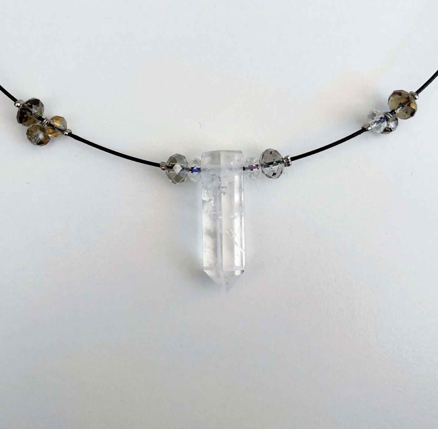 Detail view of clear quartz pendant strung onto choker with crystal beads 2cm apart all around.