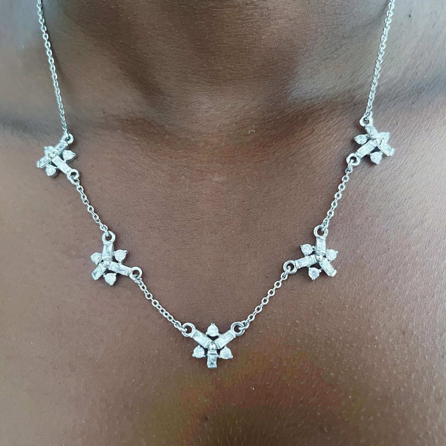 Detail view of necklace, with small cubic zirconia floral design stations, alternating with silver chain.