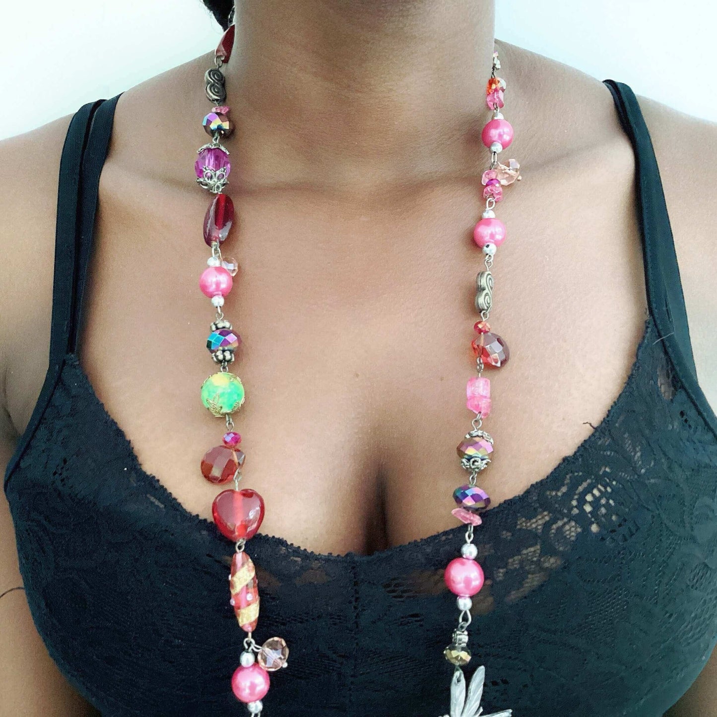 Detail view of necklace, with reds, greens, pinks, crystal, acrylic, and glass beads.