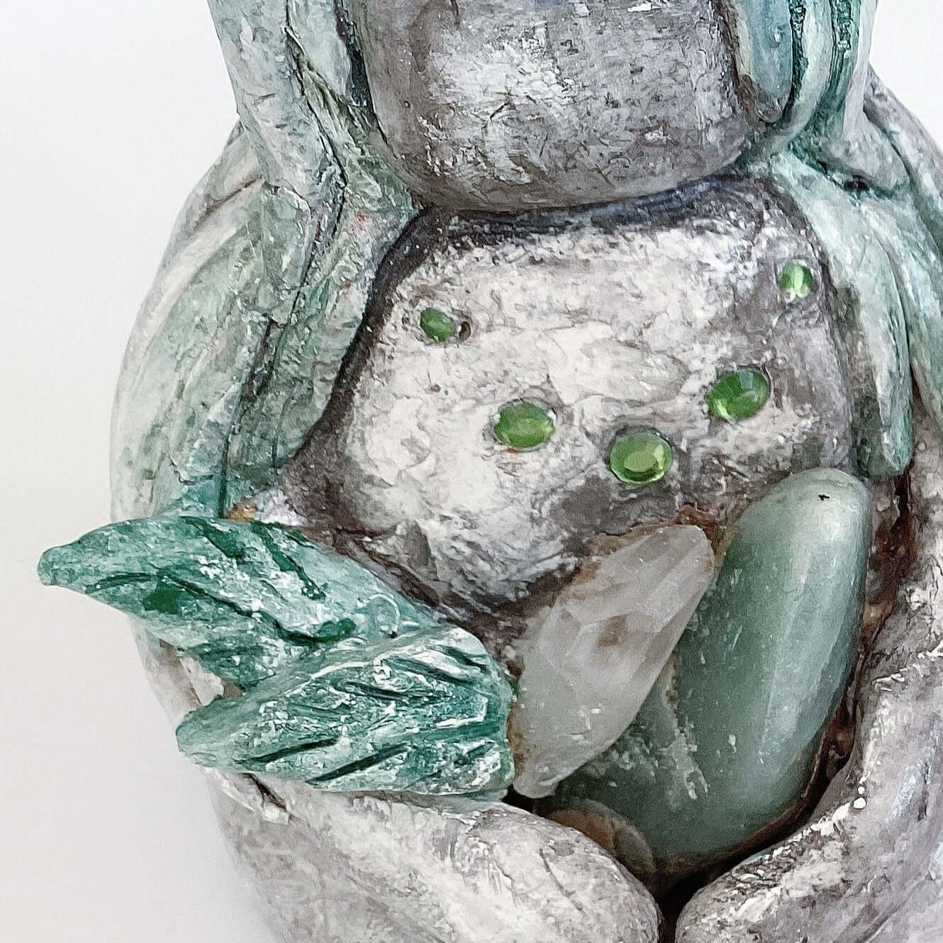 Close up of elemental, brown wash painted figure, holding crystals and clay leaves.