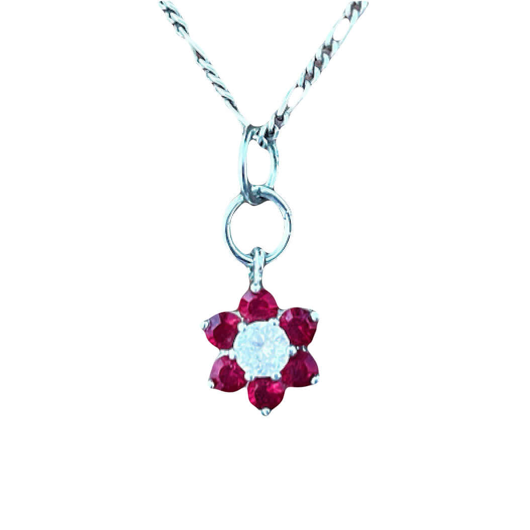 Detail view flower shaped pendant with six garnet petals and a cubic zirconia center, on silver chain, white background.