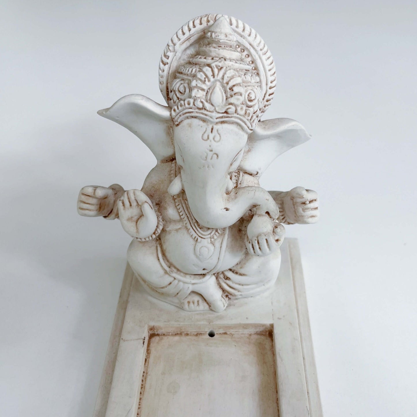 Detail view of Ganesha sitting at one end of long rectangle.