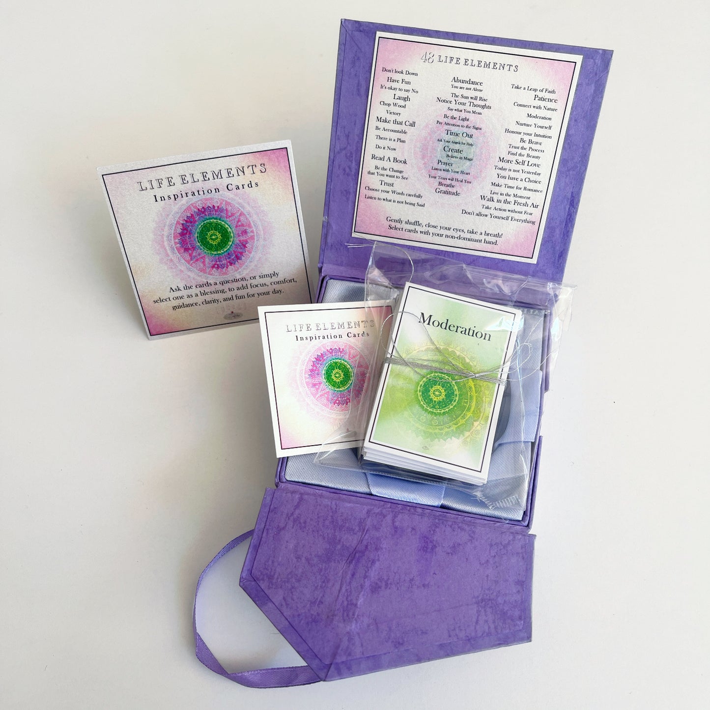 View of open box with the cards wrapped in plastic inside the box
