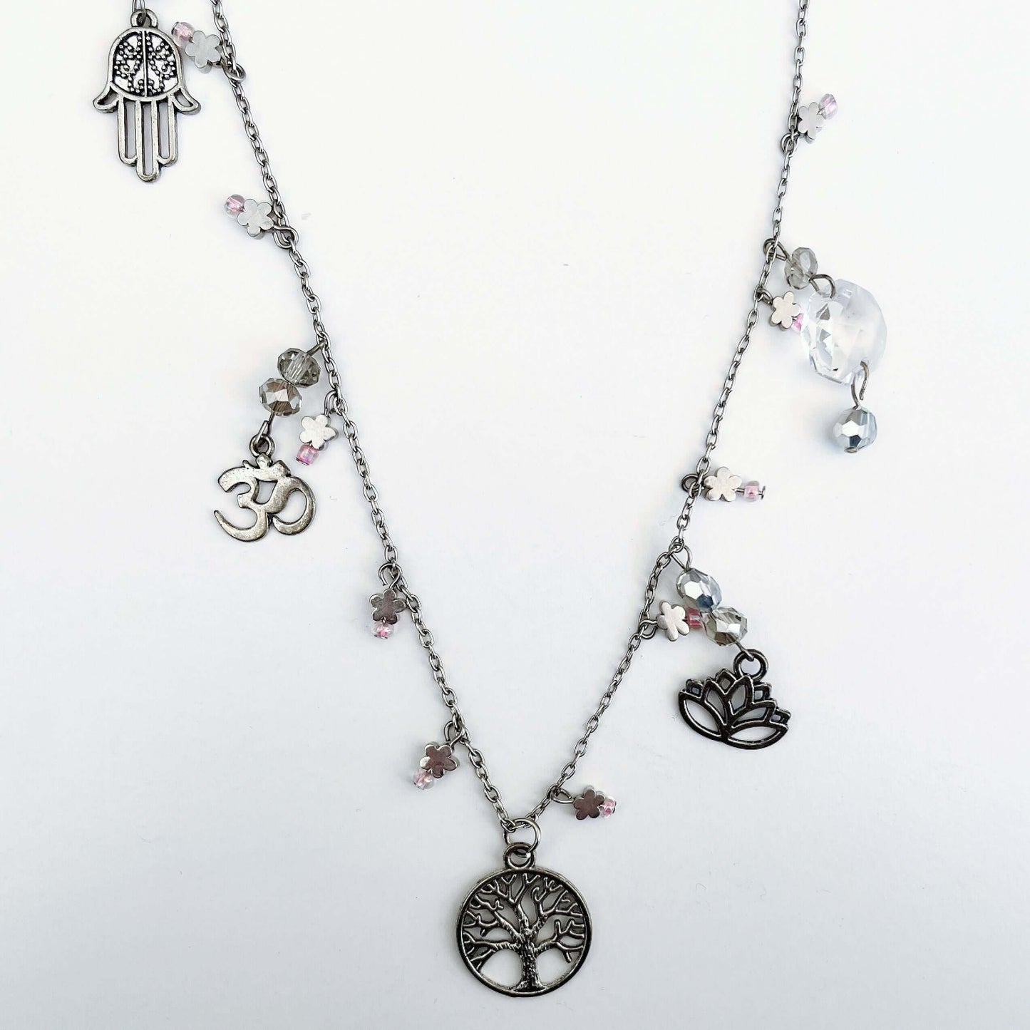 Top view of charm necklace, tree of life at the center front, with charms and beads added elsewhere.