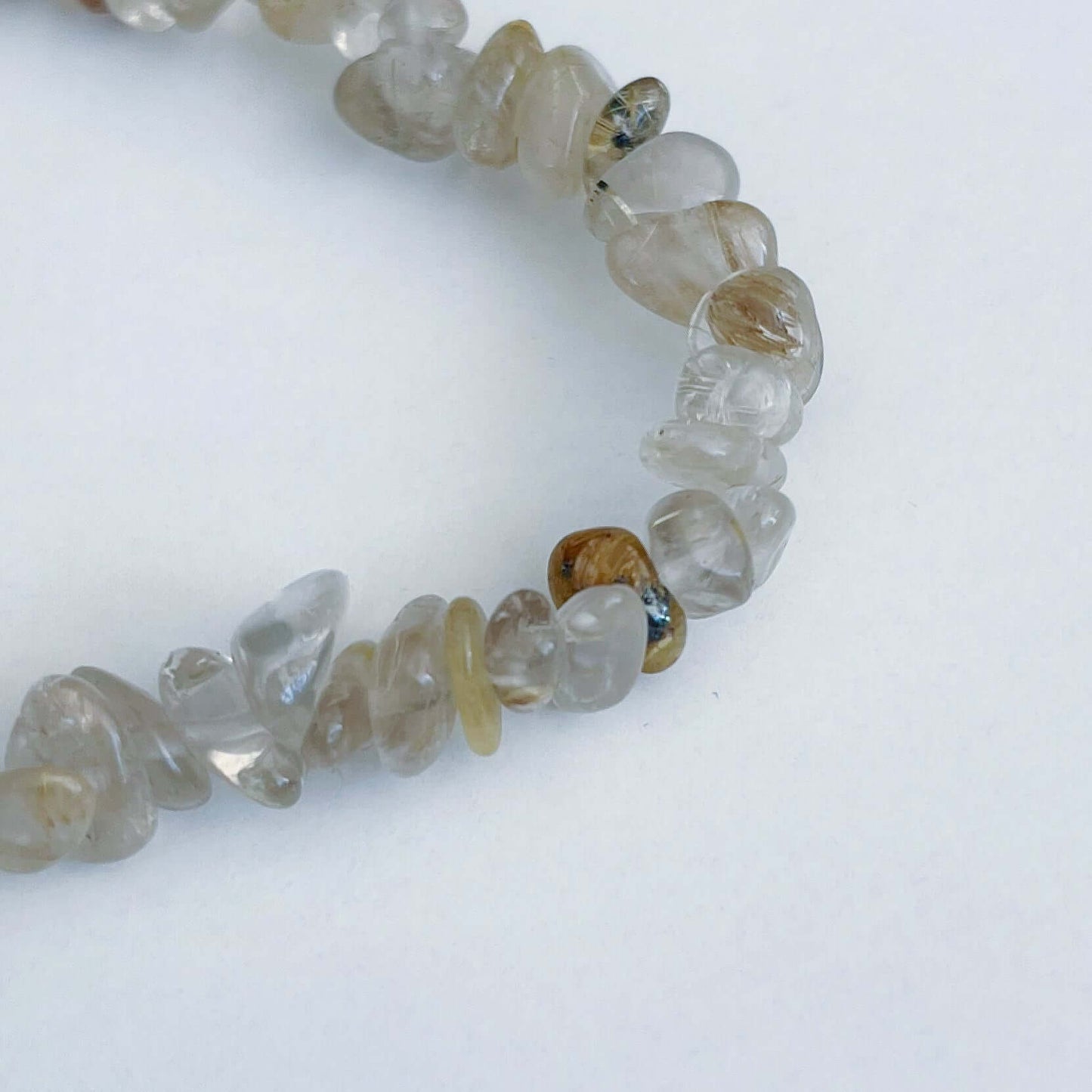 Detail view of the tumbled semi-precious stones, clear and light beige.