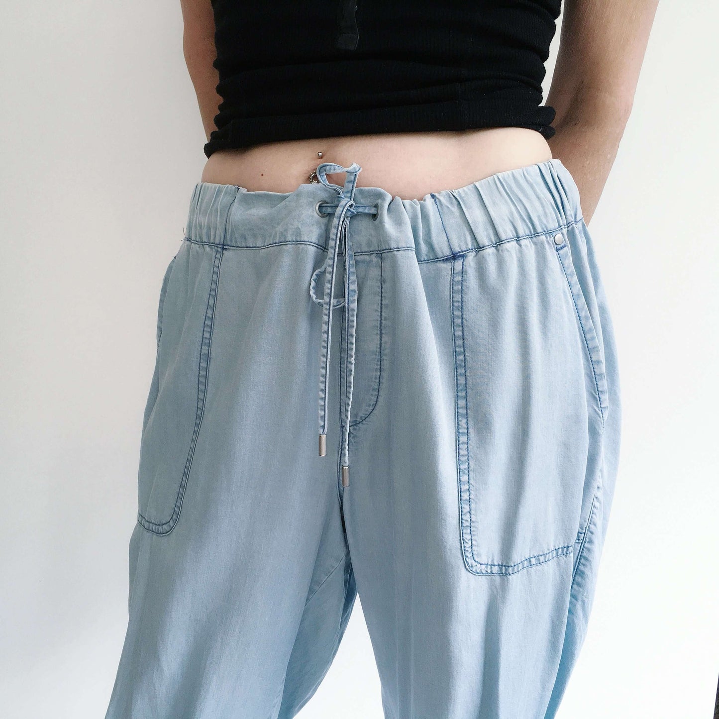 Detail view of pale blue elasticated pants with drawstring.