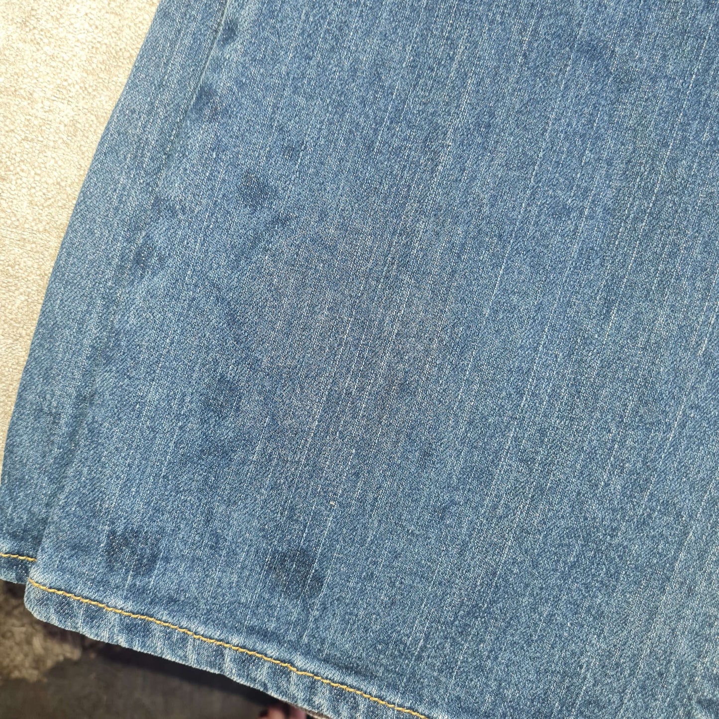 View of faded glue stains on right hem in the front.