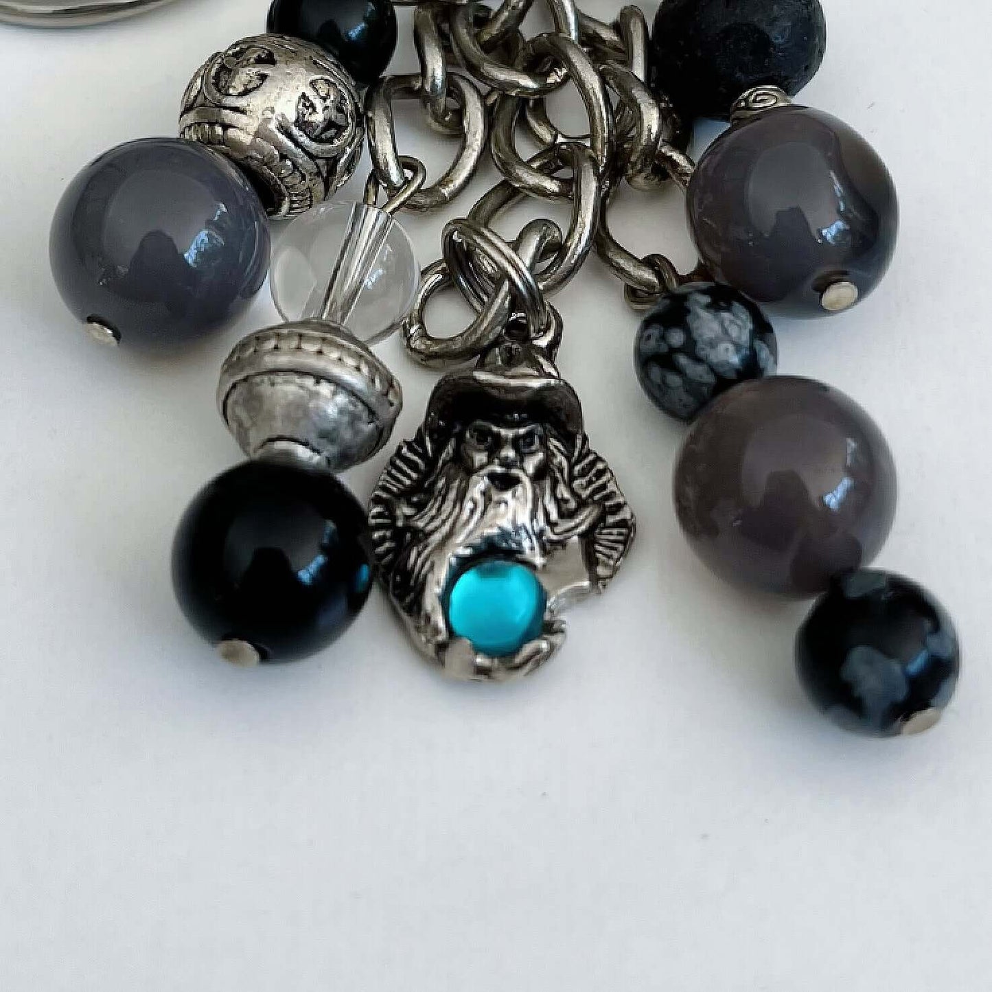 Detail view of keyring showing 5 dangling chains each with beads, one with wizard charm containing a turquoise diamanté.