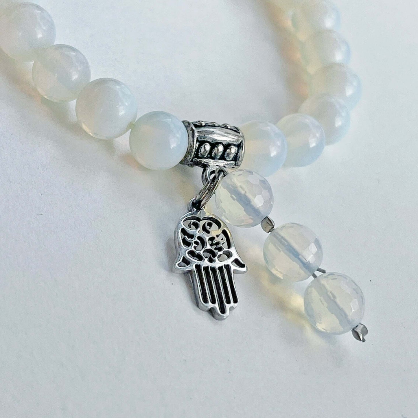 Detail view of the bracelet, with Hamsa hand and 3-bead dangle.
