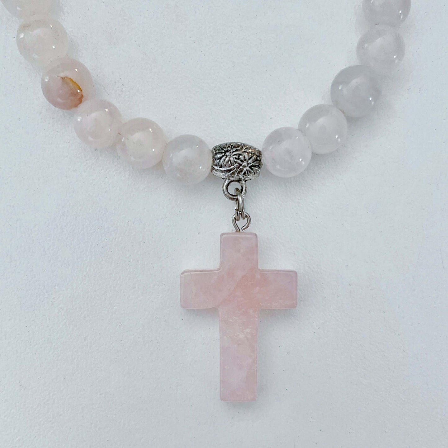 Detail view of beaded bracelet with matching Rose Quartz cross.