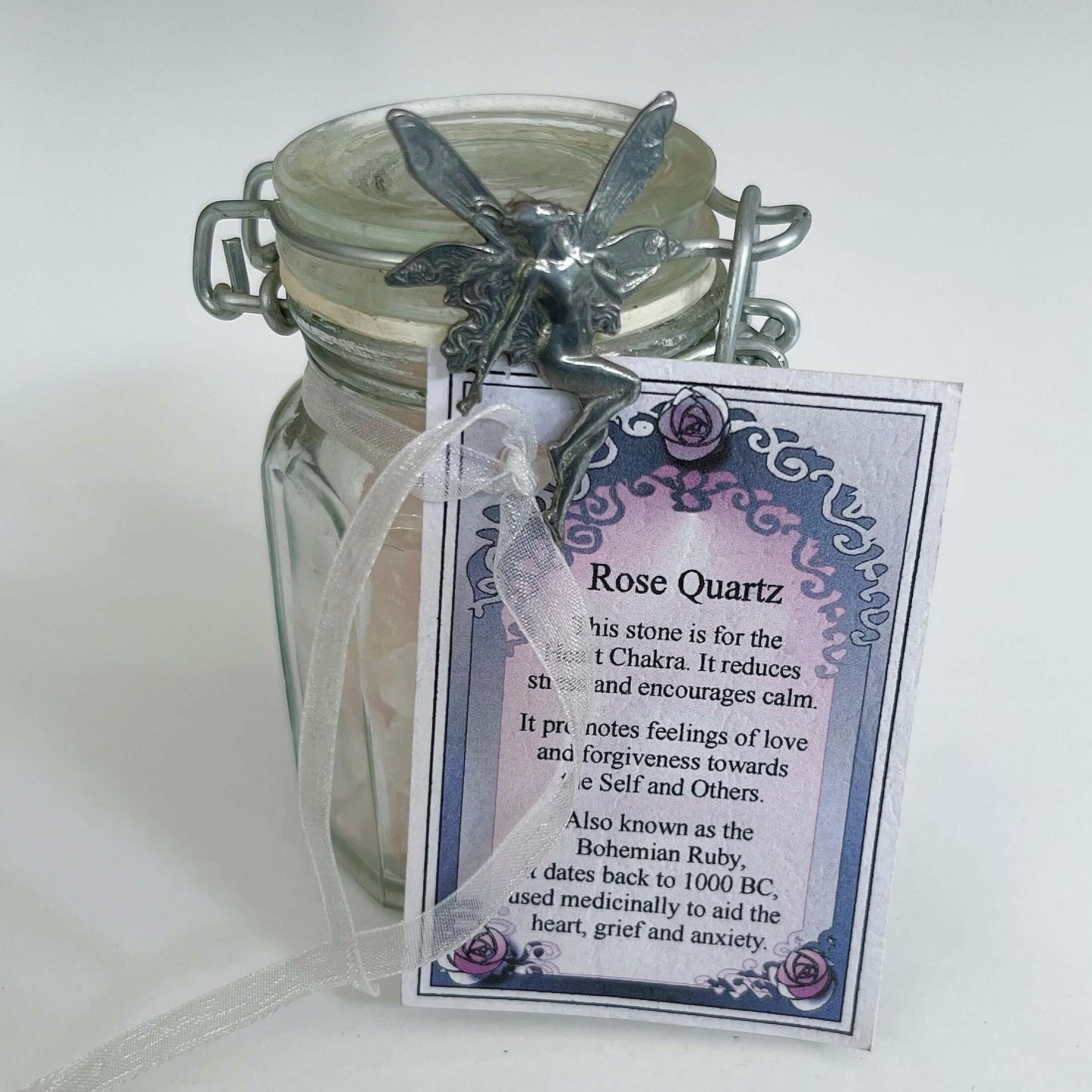Detail view of bottle showing the pewter fairy and the rose quartz inscription card.