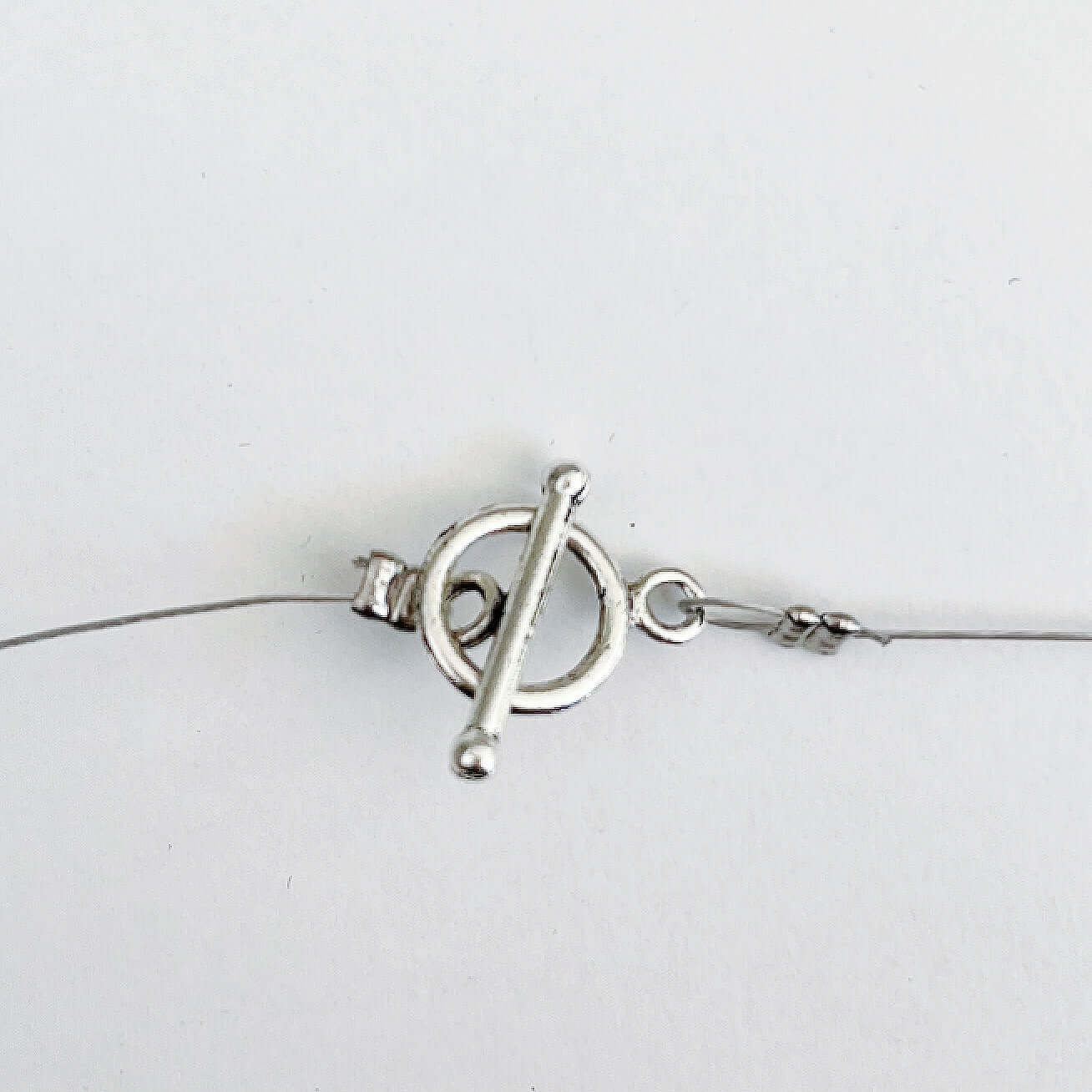Detail view of the silver finish toggle and bar clasp.