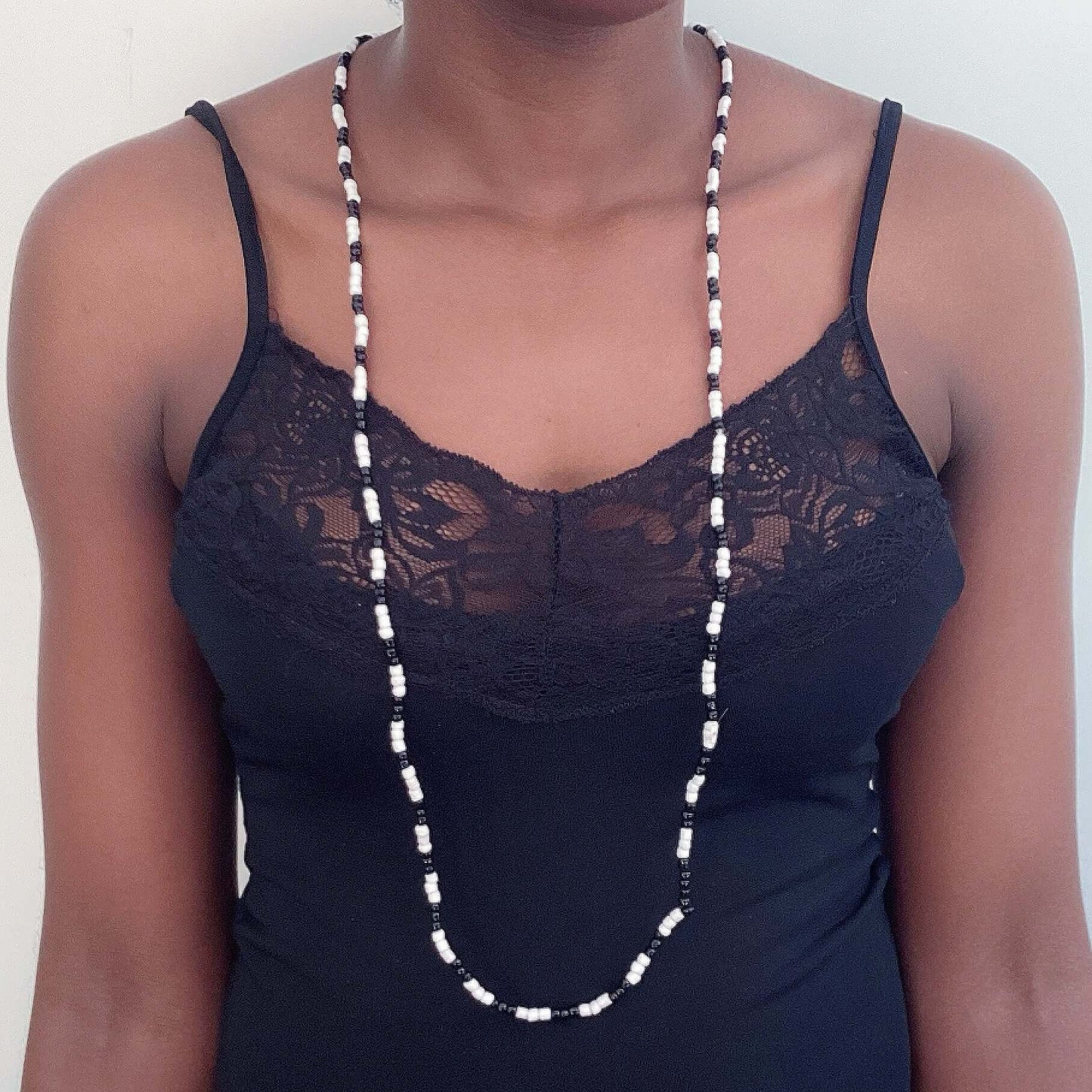 Zulu necklace hanging loose in front, alternating black and white, approximately 3mm beads.