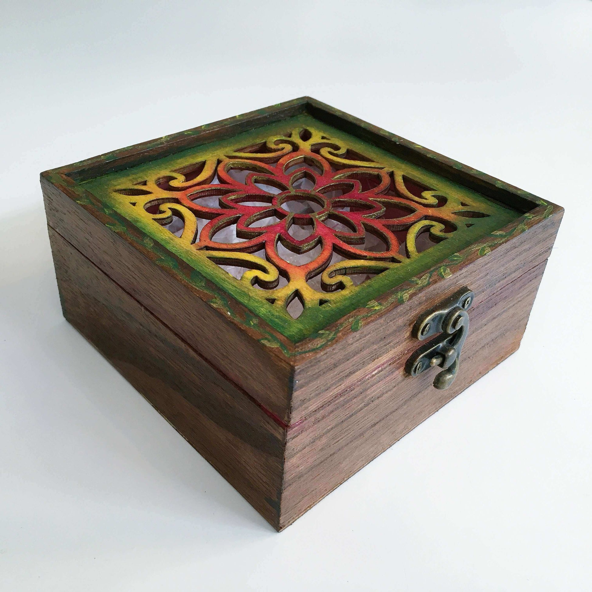 Outside view of brown painted box, blending into rainbow shades on flower shape laser cut lid, metal closing clasp.