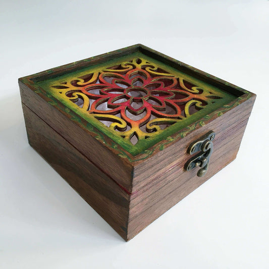 Outside view of brown painted box, blending into rainbow shades on flower shape laser cut lid, metal closing clasp.