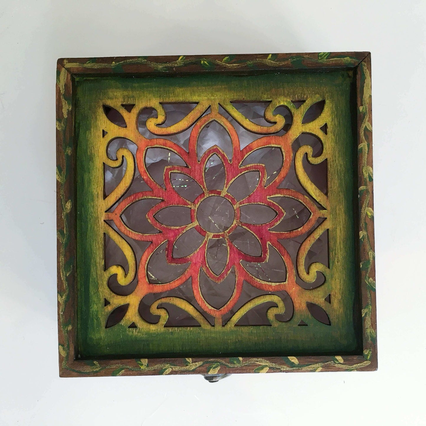 Detail view of rainbow box lid painting fading from brown through to yellow, range, red center.
