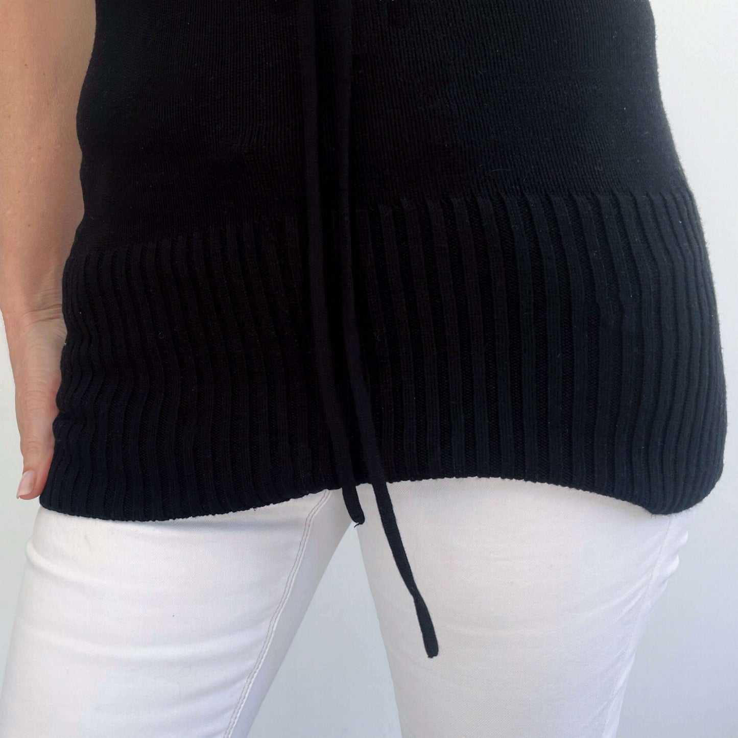 Detail view of knitted jersey, with the wide ribbed hem. Just beyond hip length.