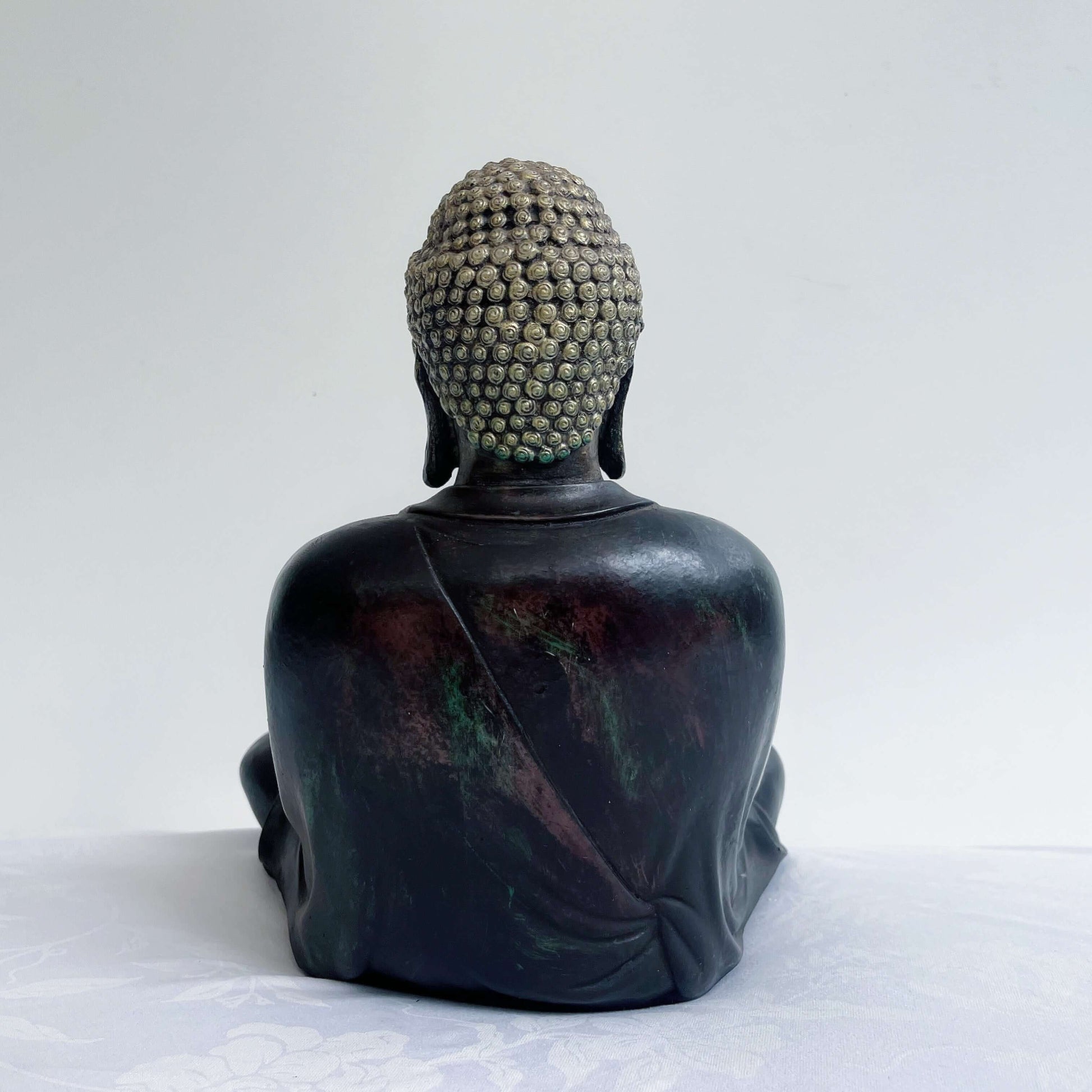 Back view of buddha, smooth painted ebony robes and gold painted head.