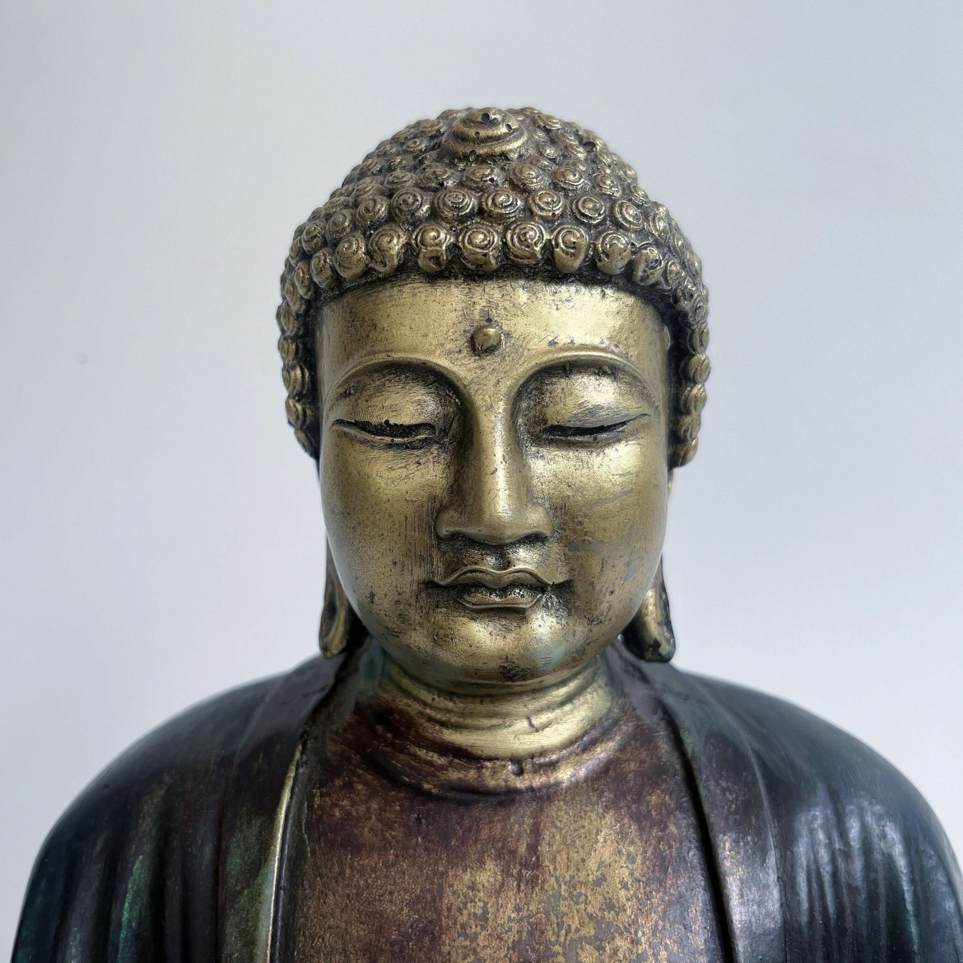 Close up view of buddha's head, the eyes almost closed looking down.
