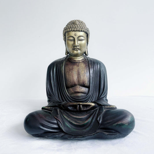Front view of gold and ebony buddha in the meditation position, overall surface is smooth, the robes do not cover the chest area.
