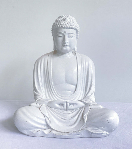 Front view of white buddha in the meditation position, overall surface is smooth, the robes do not cover the chest area.