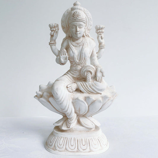 Front view of Lakshmi, natural off white color, resting on lotus flower and pedestal.
