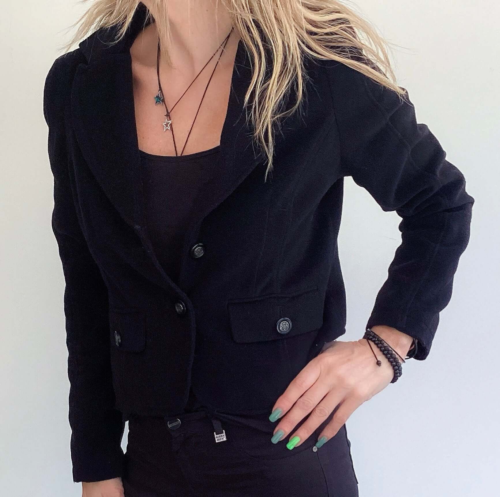 Front view of buttoned jacket, two buttoned side pockets, waist length.