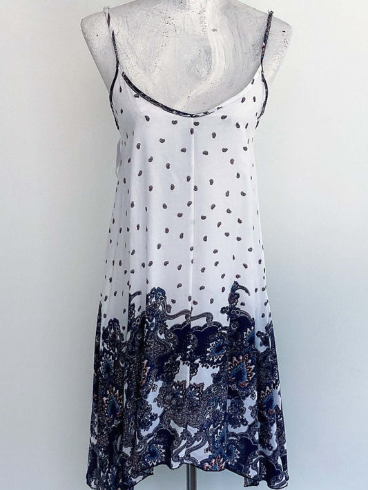 Front view of dress, top half of dress is white with paisley print, bottom half bold navy blue paisley print.