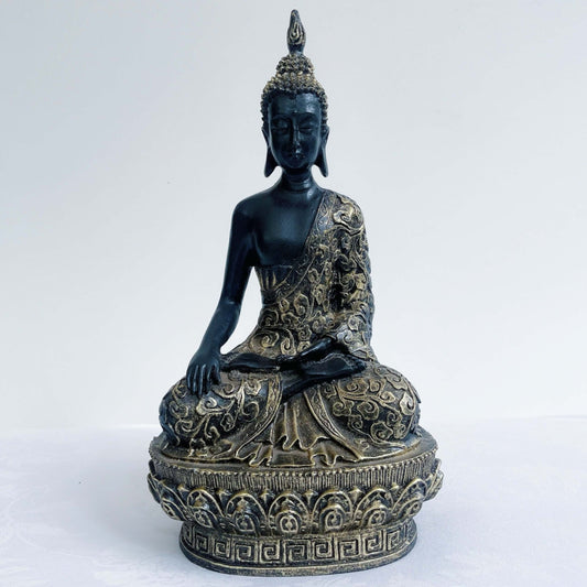 Front view of buddha in lotus position, black and gold paint wash, ornate robes and pedestal, ushnisha on head.