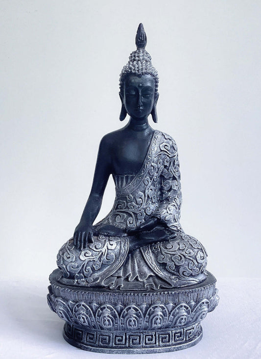 Front view of buddha in lotus position, black and silver paint wash, ornate robes and pedestal, ushnisha on head.