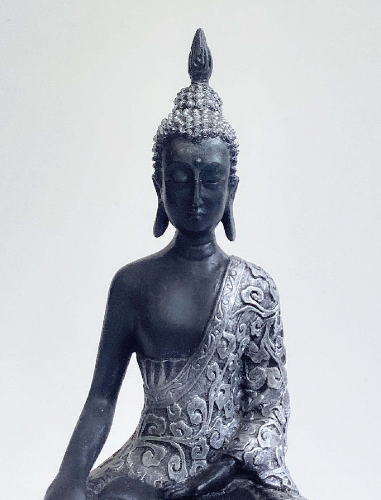 Front detail view of buddha torso, black and silver paint wash, ornate robes, with ushnisha on head.