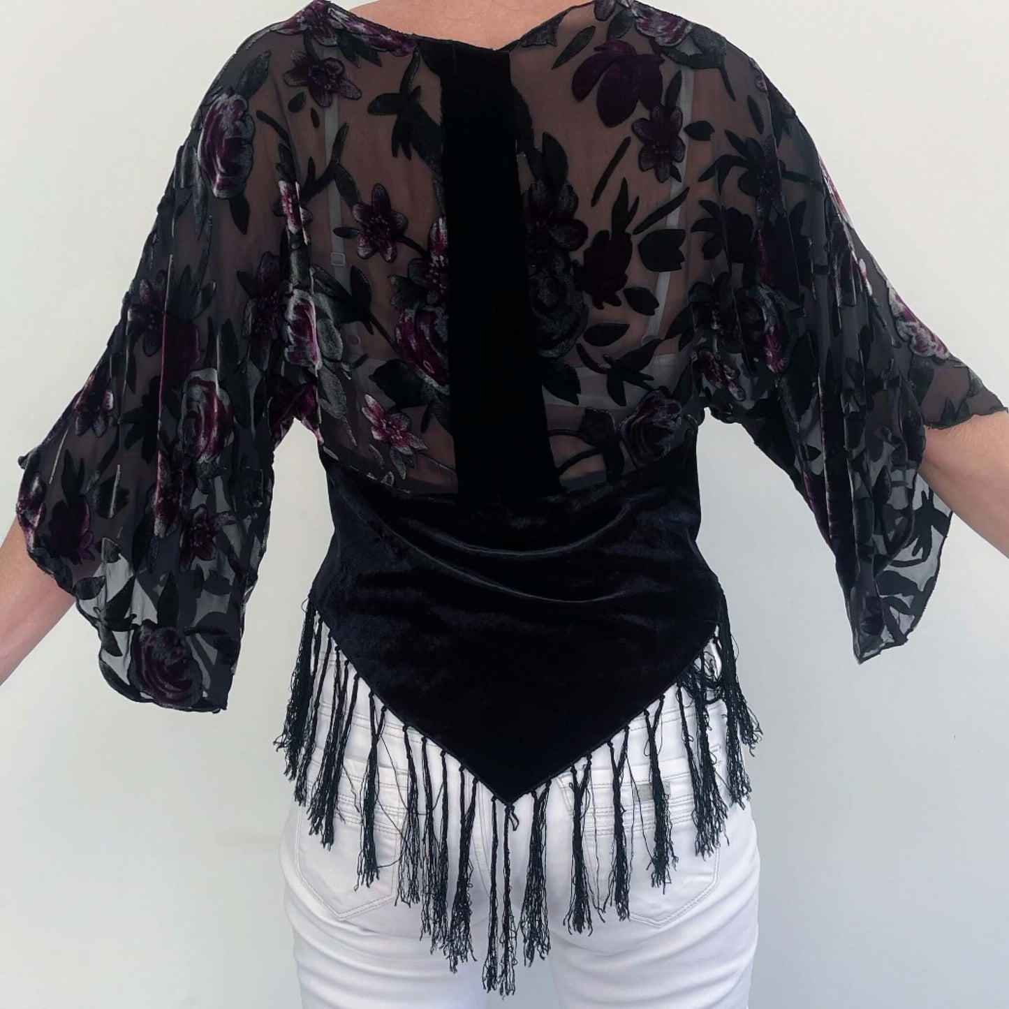 Back view of top, burn-out silk bodice and velvet torso with black fringing on the v-shaped hem front and back.