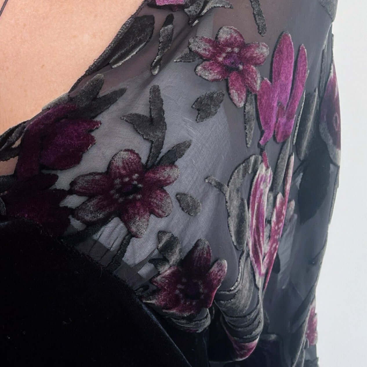 Detail view of the floral silk burn-out, in shades of black, grey, and plum/maroon.