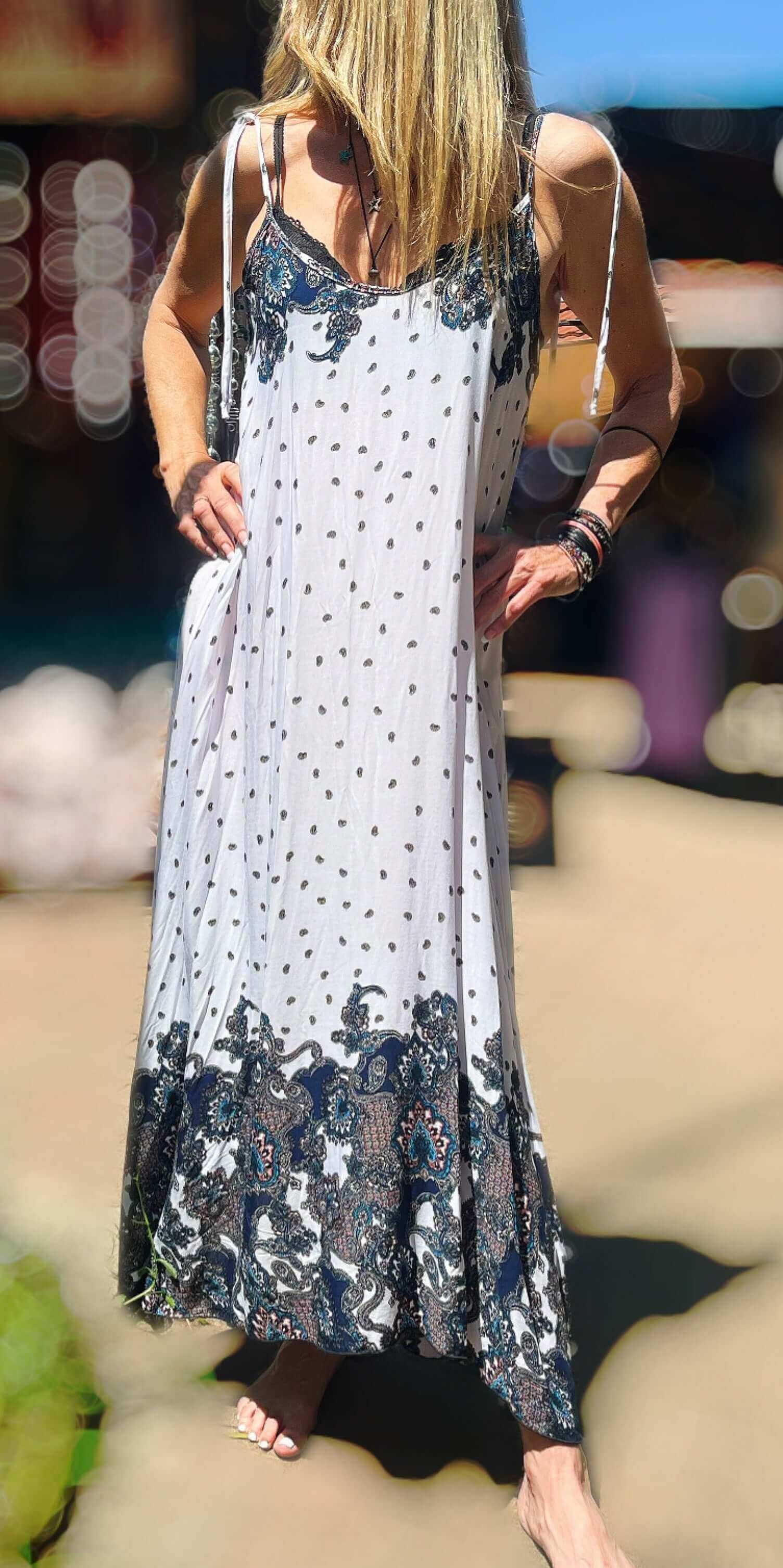 Front view of dress, basic white with small black print motif all over, with bolder indian pattern at the neck and on hem.