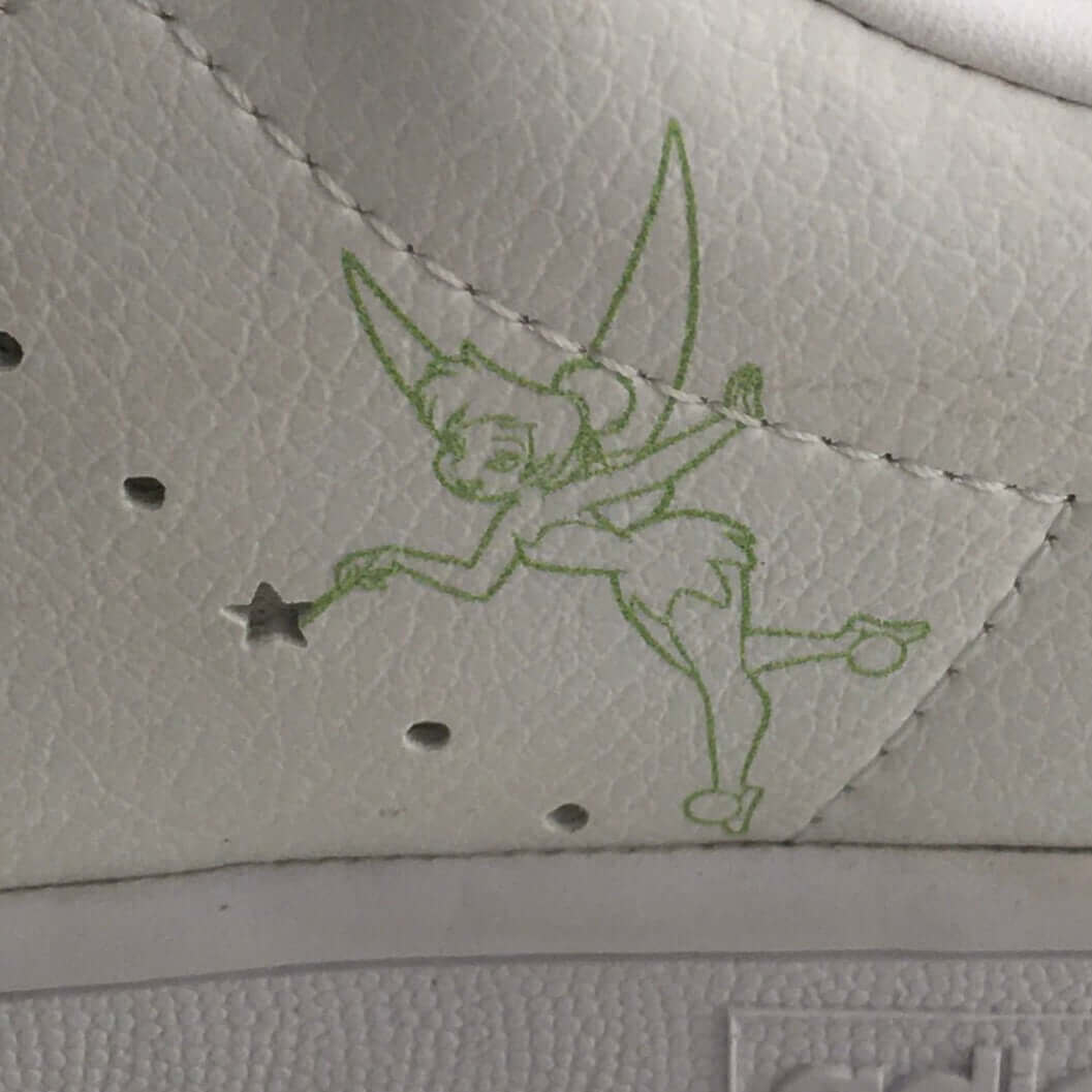 Close view of tinkerbell in green outline printed on outside of both shoes, tip of wand is a star shaped air perforation.