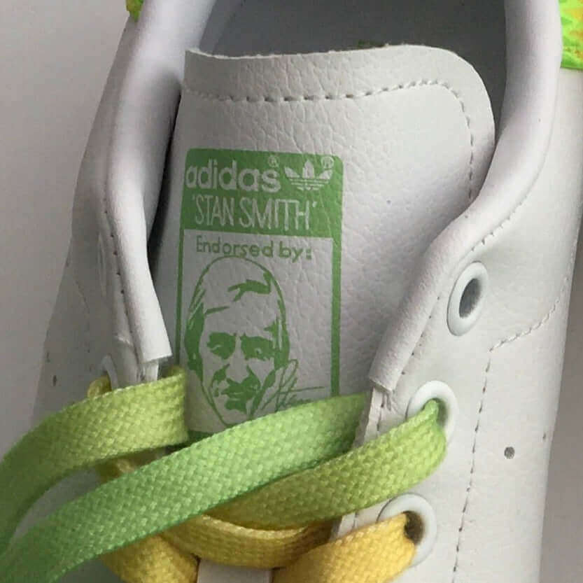 Close up of shoe tongue beneath the laces, showing logo of the adidas stan smith endorsement.