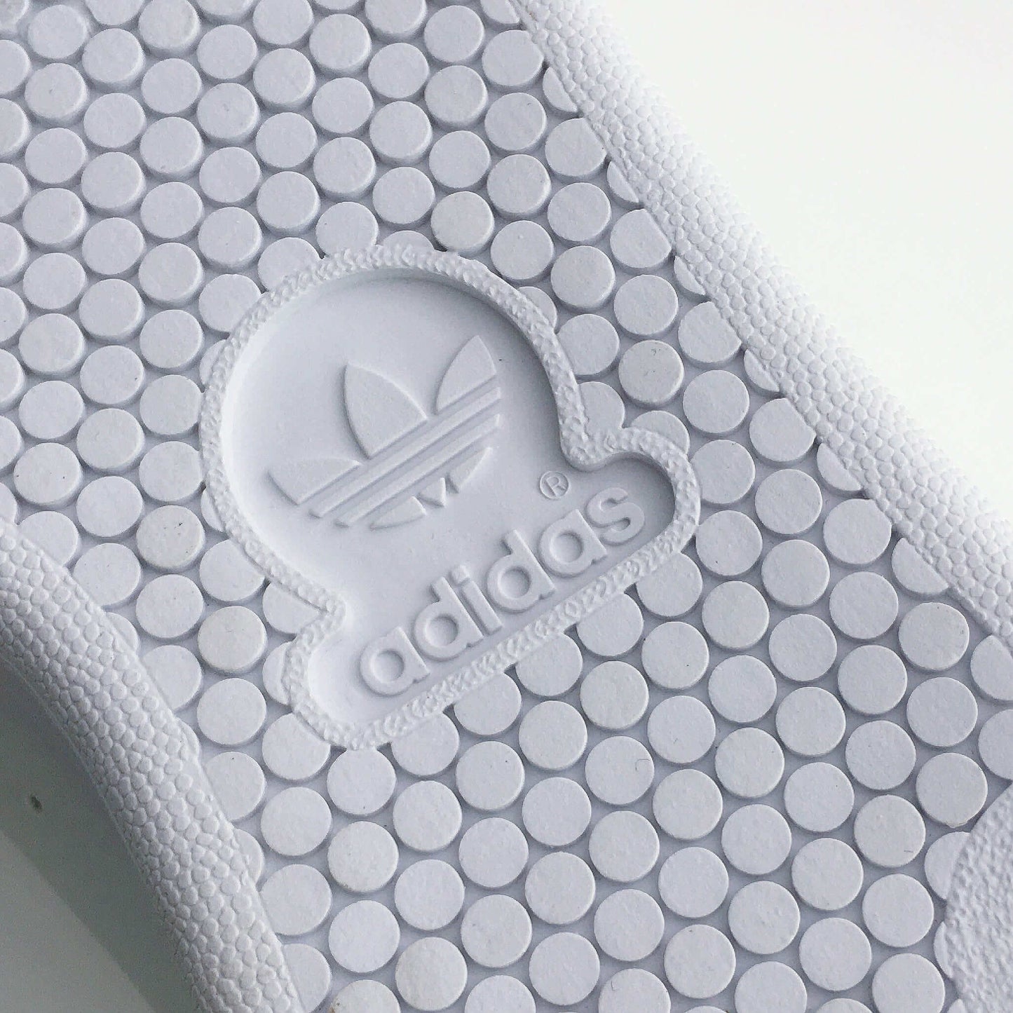 Sole of shoe with adidas logo imprinted into the rubber.