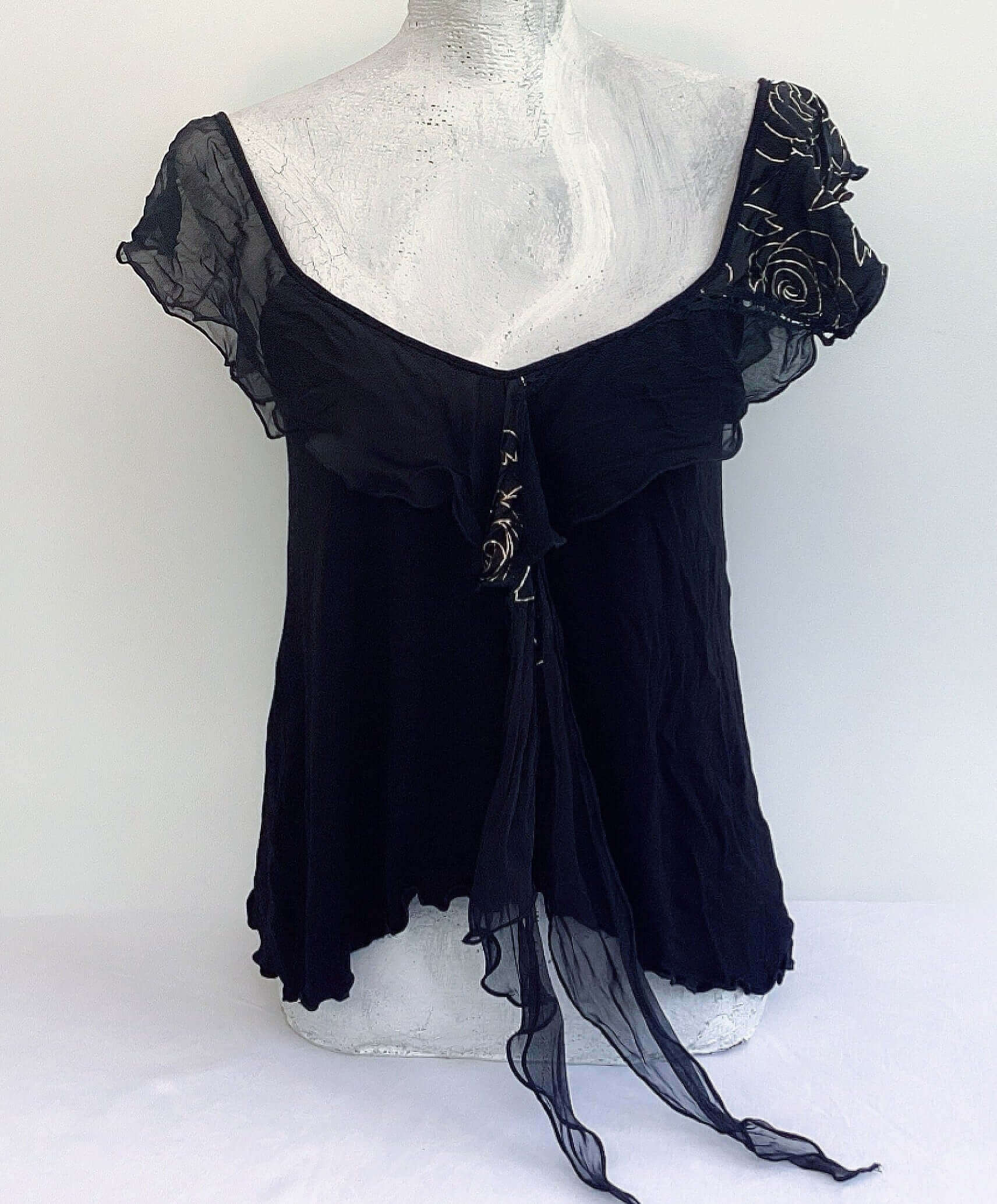Front view of camisole, contrasting, patterned, wide chiffon frill straps, joining at center bust, flowing down in front.