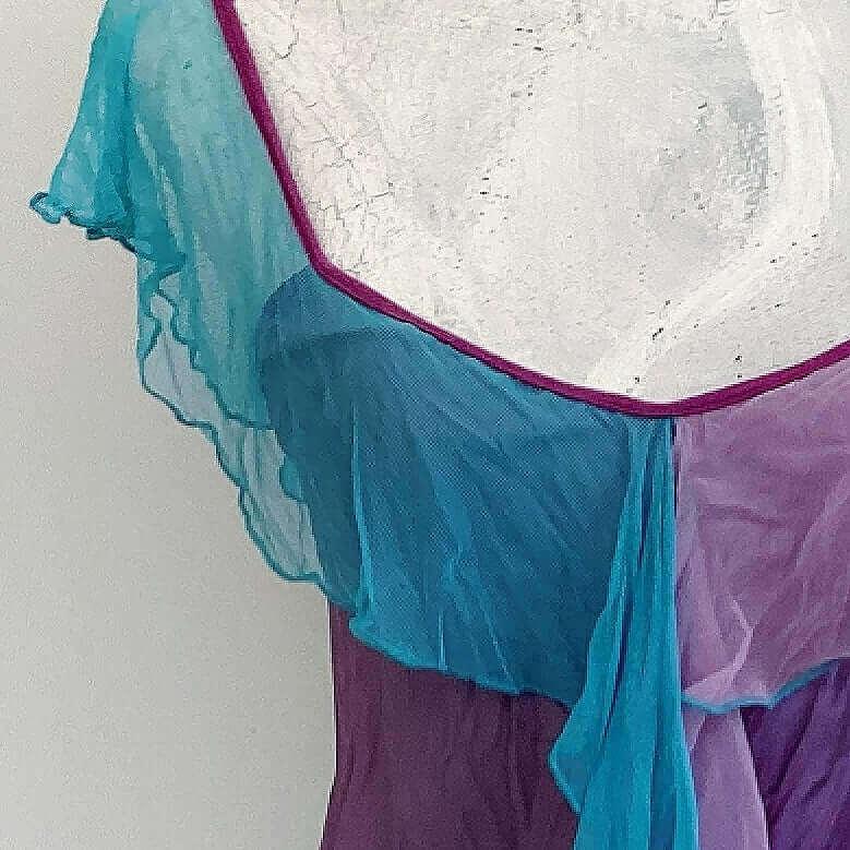 Sleeve view of camisole, contrasting, patterned, wide chiffon frill straps, joining at center bust, flowing down in front.