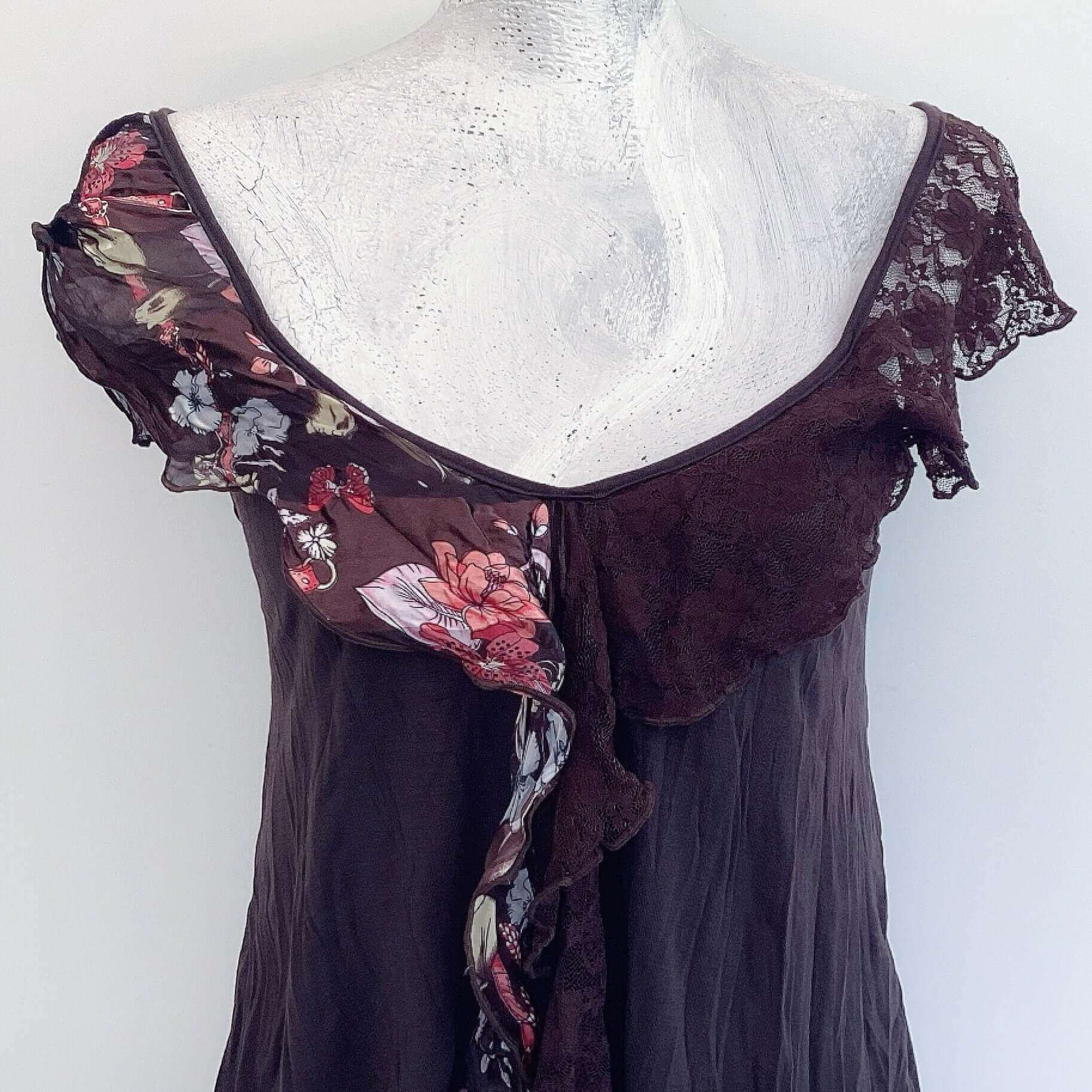 Detail of camisole, contrasting, patterned, wide chiffon frill straps, joining at center bust, flowing down in front.