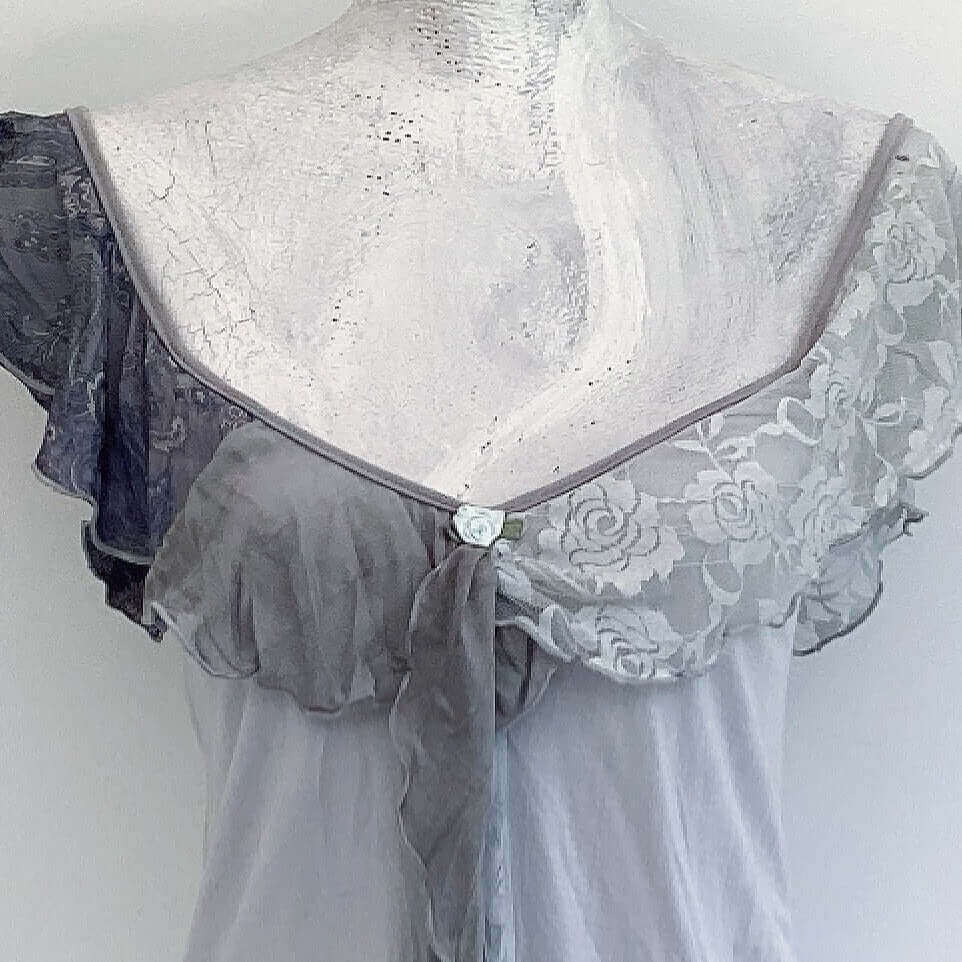 Detail of camisole, contrasting, patterned, wide chiffon frill straps, joining at center bust, flowing down in front.