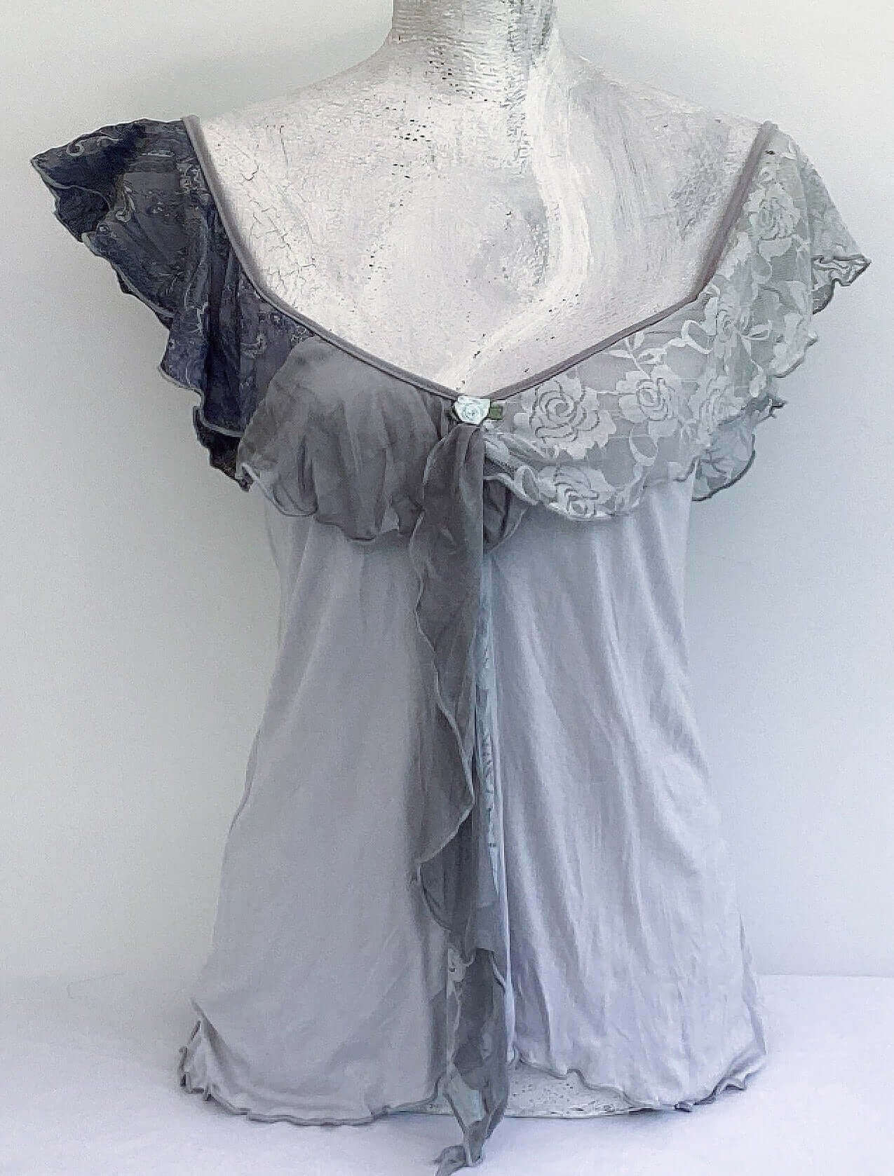 Front view of camisole, contrasting, patterned, wide chiffon frill straps, joining at center bust, flowing down in front.