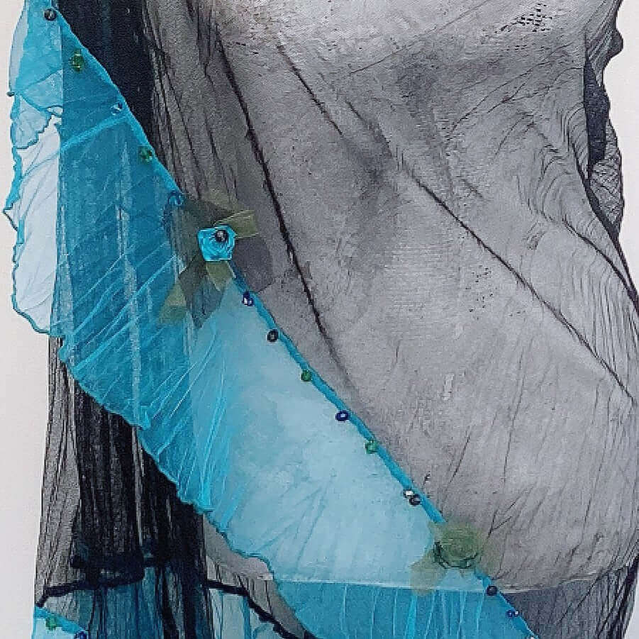 close-up view of black net shawl with turquoise trim lined with hand-stiched flowers and crystal beads