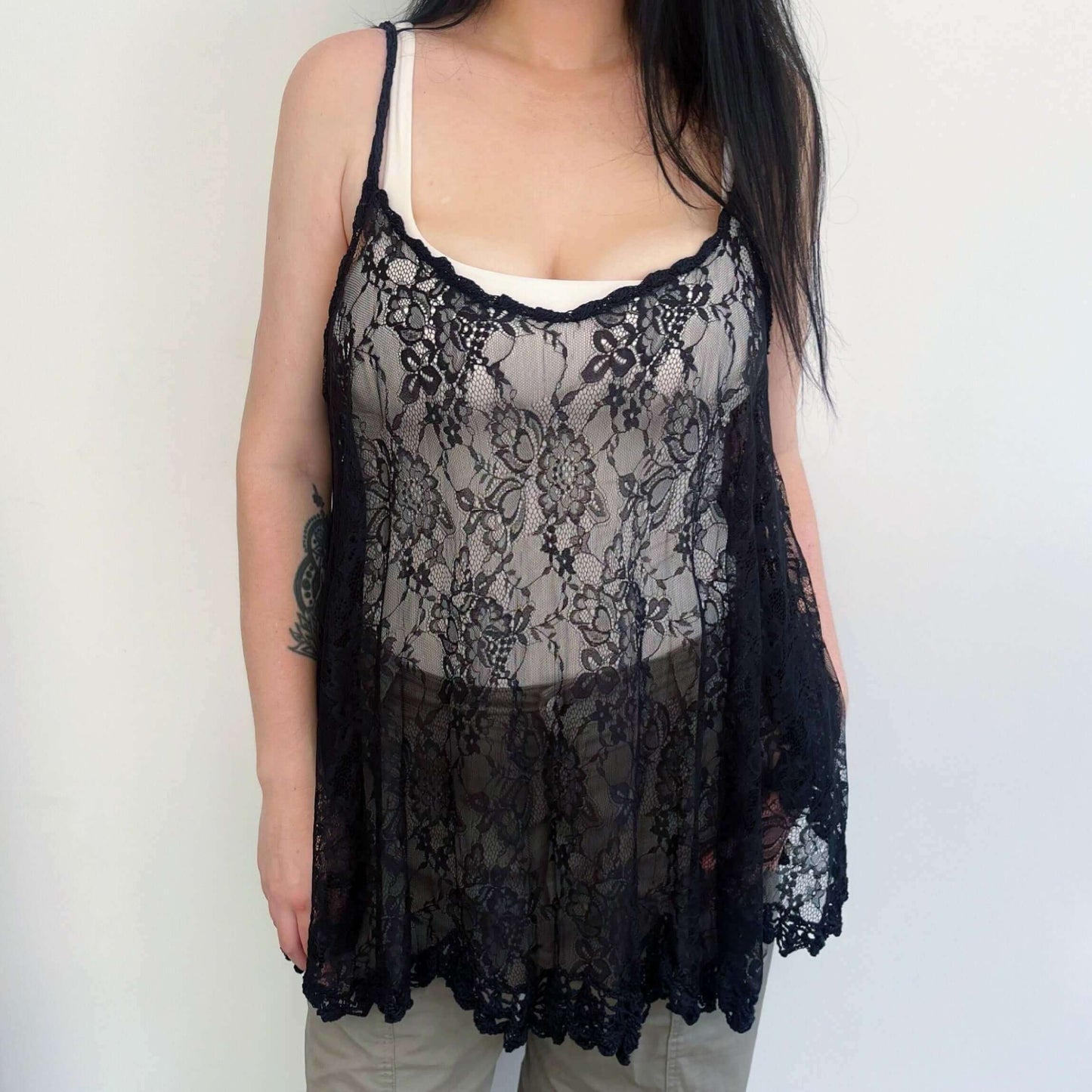 Front view of black lace swing top, wide scalloped hem, with a band of black crochet on the hem and straps.