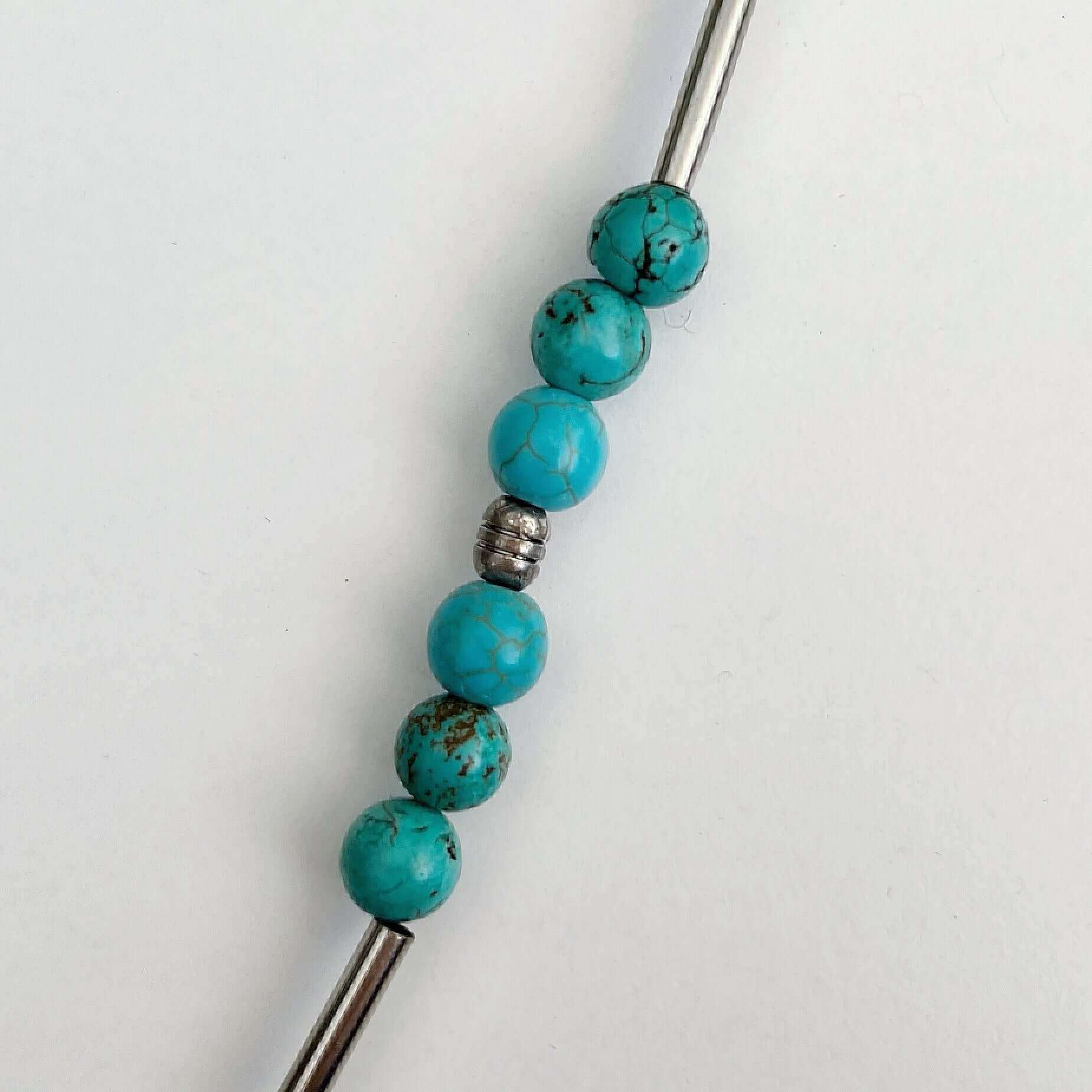 Detail view of the smooth round beads, with silver finish tubular beads in-between.