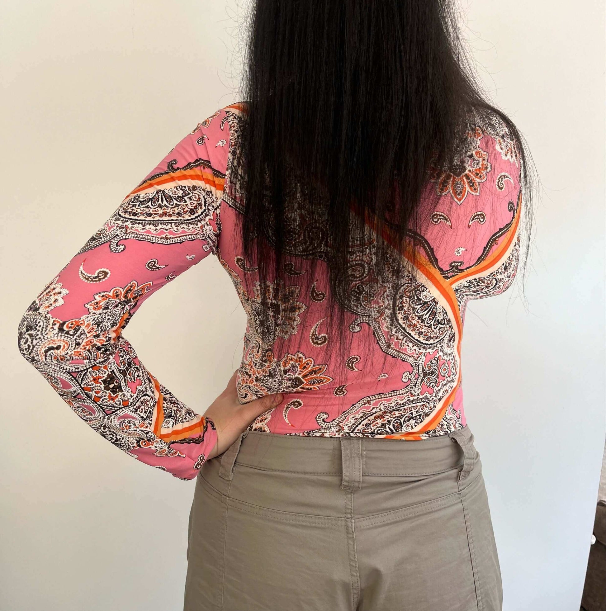 Side view of lycra top, very detailed floral and geometric print, in pink, orange, brown and white.