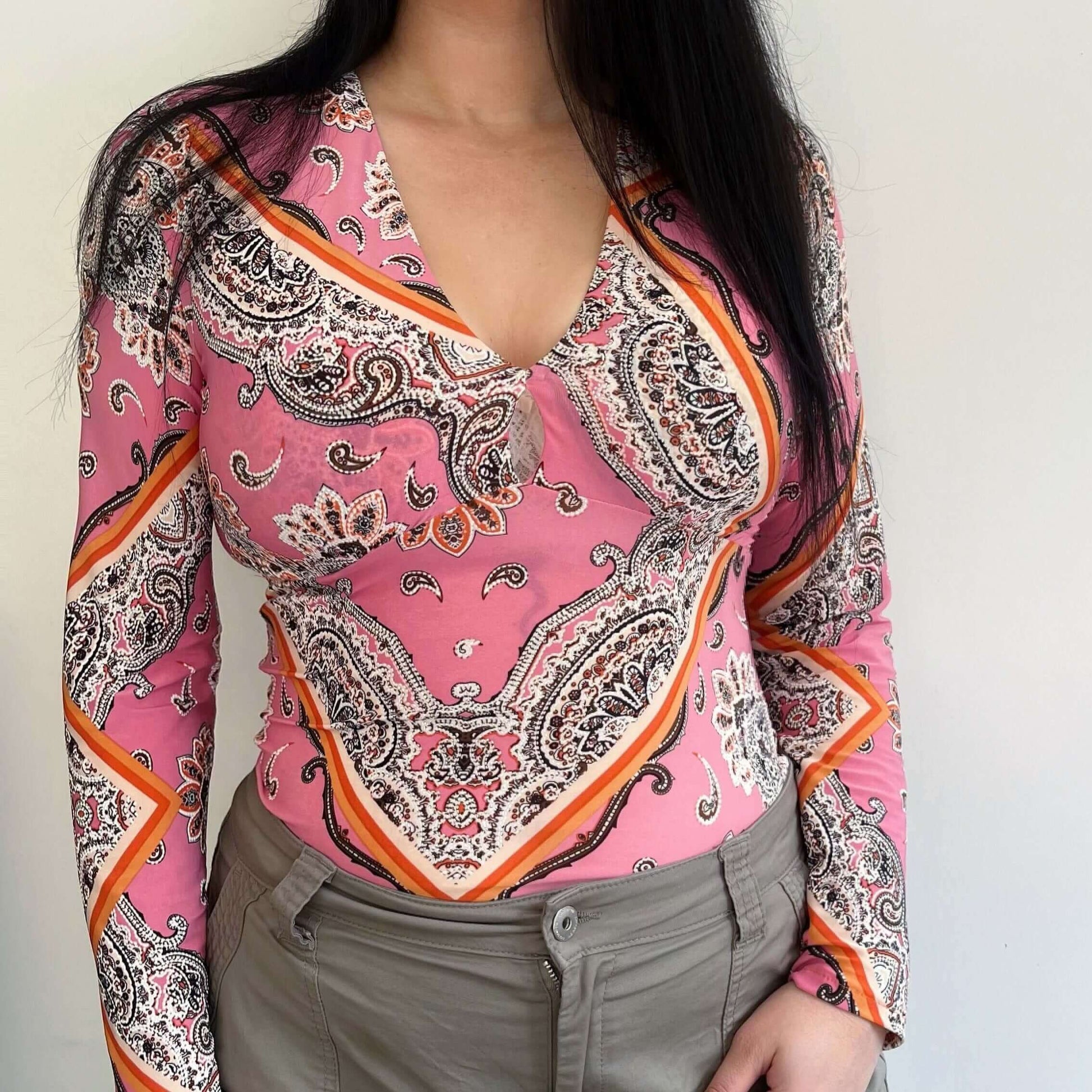 Front view of lycra top, very detailed floral and geometric print, in pink, orange, brown and white.